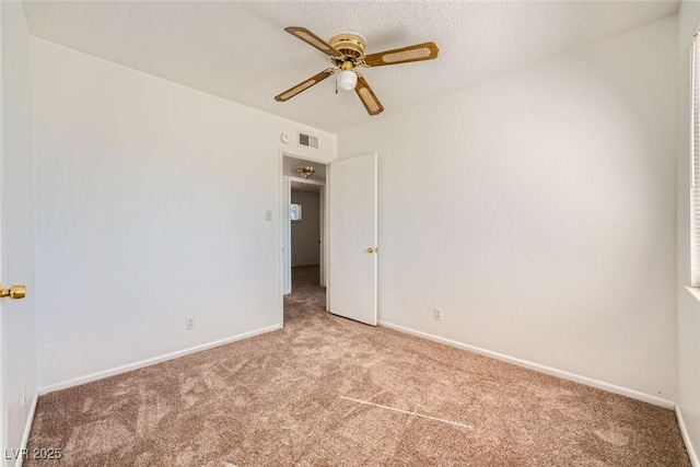 unfurnished bedroom featuring light colored carpet, visible vents, baseboards, and a textured ceiling