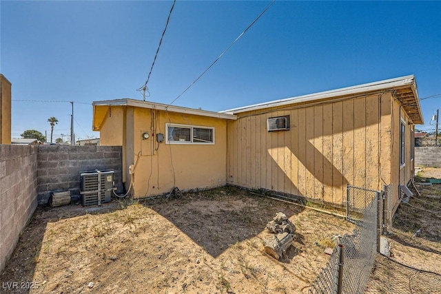 view of outdoor structure featuring central air condition unit and fence