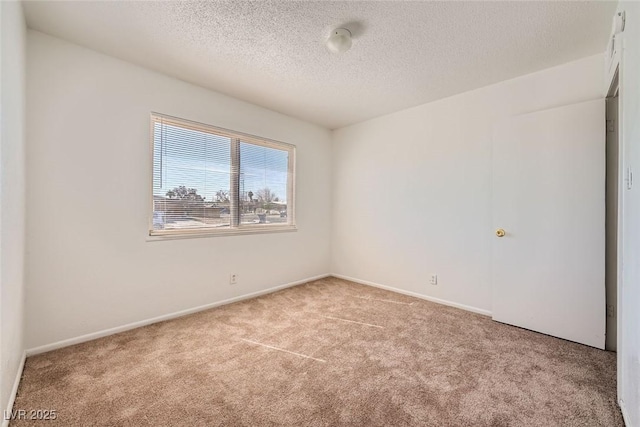 carpeted empty room with baseboards and a textured ceiling