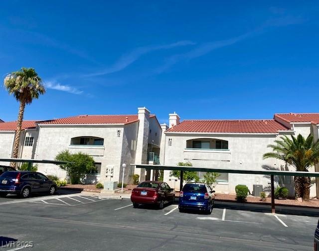 view of property with covered and uncovered parking