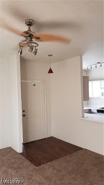 entrance foyer with dark colored carpet and a ceiling fan