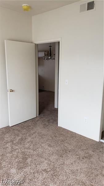 unfurnished bedroom featuring carpet, visible vents, and a closet