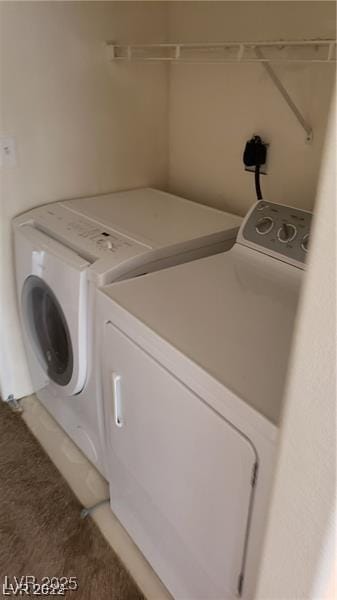 laundry area featuring washing machine and dryer, laundry area, and light carpet