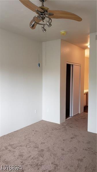 carpeted empty room featuring a ceiling fan