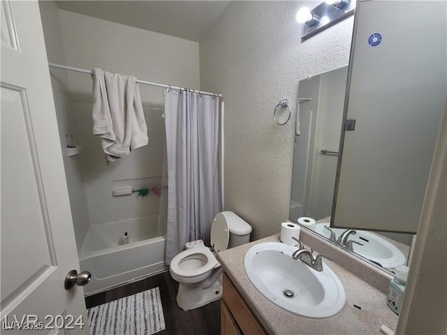 bathroom with shower / bath combination with curtain, a textured wall, toilet, vanity, and wood finished floors