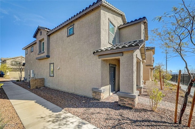 view of home's exterior with a tiled roof and stucco siding