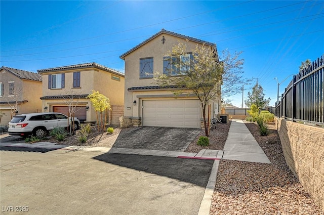 view of front of house featuring central AC unit, a garage, fence, decorative driveway, and stucco siding