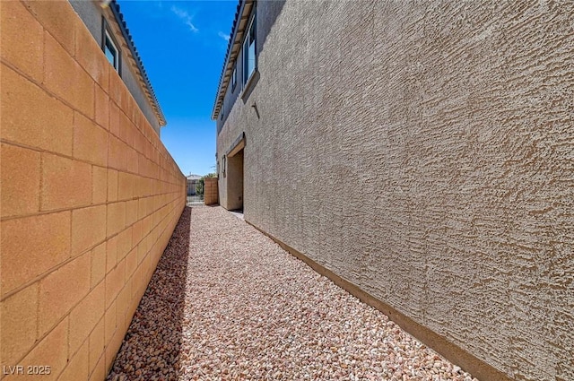 view of home's exterior with fence and stucco siding