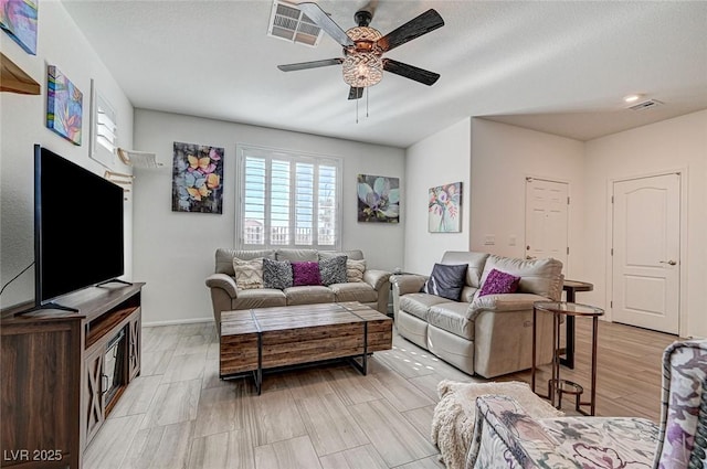 living area featuring light wood-style floors, visible vents, and a ceiling fan