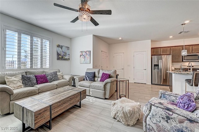 living area featuring ceiling fan and visible vents