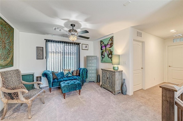 living area featuring carpet, visible vents, and a ceiling fan