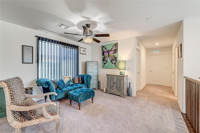 sitting room with light carpet, ceiling fan, and visible vents