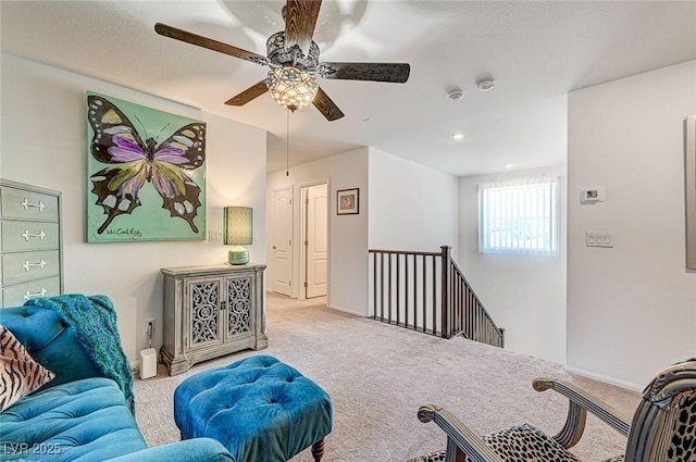 living area with carpet flooring, an upstairs landing, and baseboards