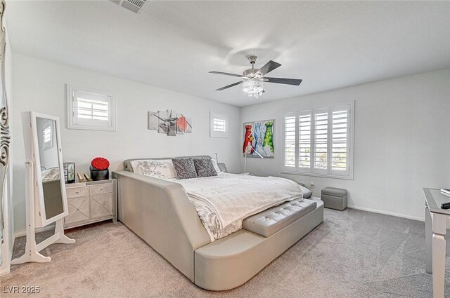 carpeted bedroom with a ceiling fan, multiple windows, visible vents, and baseboards