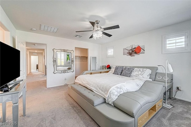 bedroom with light carpet, a ceiling fan, visible vents, and baseboards