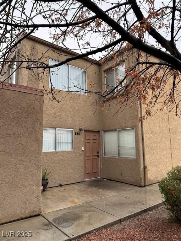 exterior space with a patio area and stucco siding