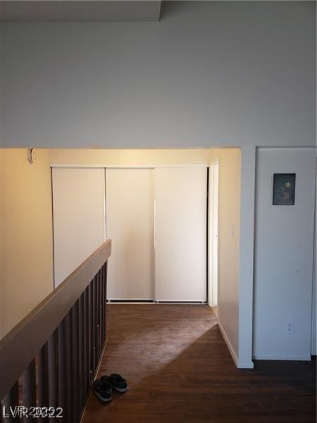 hallway featuring dark wood-style flooring and an upstairs landing