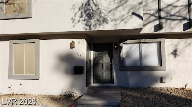 doorway to property featuring stucco siding