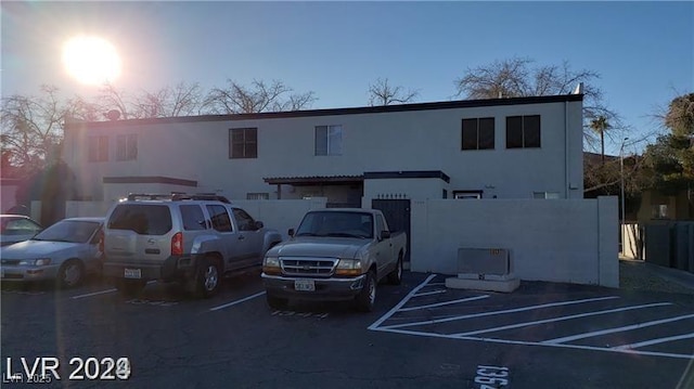 view of building exterior featuring uncovered parking and fence