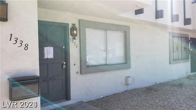 property entrance with stucco siding