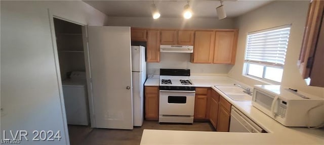 kitchen featuring under cabinet range hood, white appliances, a sink, light countertops, and light brown cabinetry