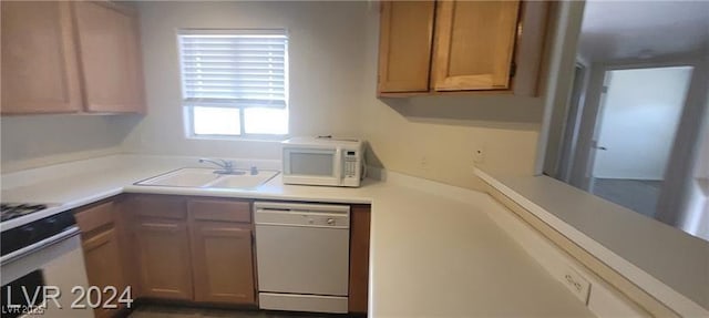 kitchen with white appliances, light countertops, and a sink