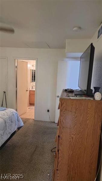 bedroom featuring visible vents, light speckled floor, and connected bathroom