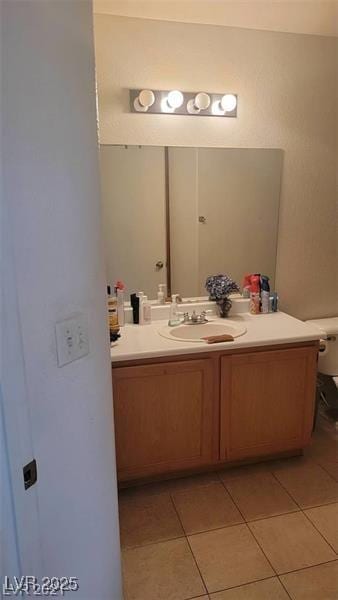 bathroom with toilet, vanity, and tile patterned floors