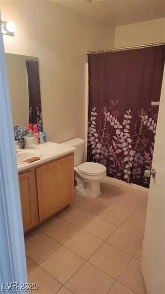 bathroom featuring toilet, a shower with shower curtain, vanity, and tile patterned floors