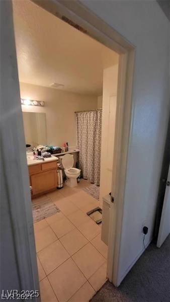 bathroom with toilet, a shower with shower curtain, tile patterned flooring, and vanity