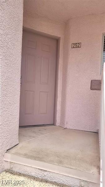 entrance to property featuring stucco siding