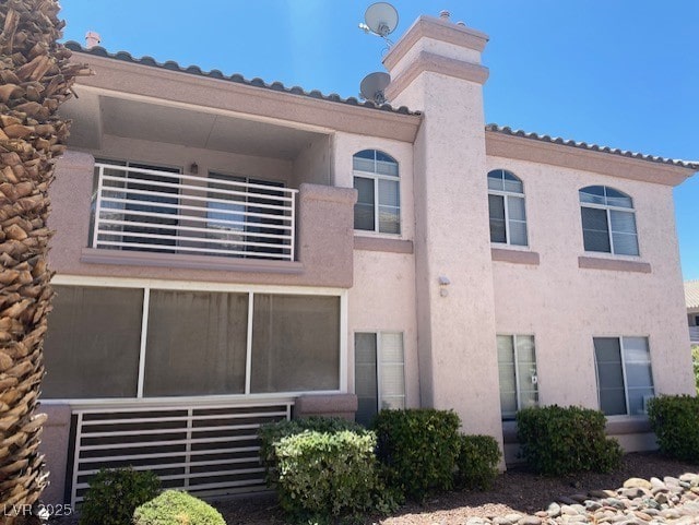 view of front facade featuring a chimney and stucco siding