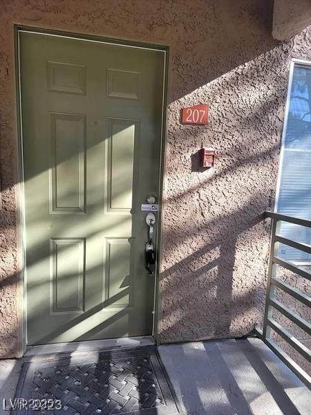 doorway to property featuring stucco siding