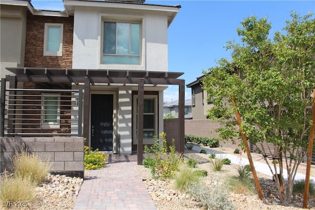 view of front of home featuring a pergola, fence, and stucco siding