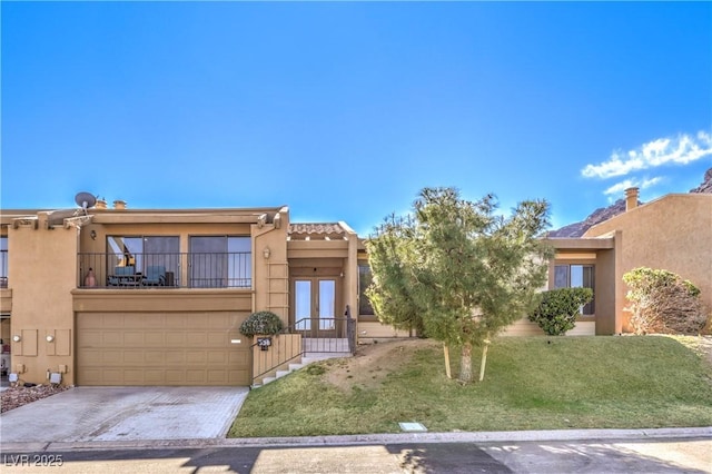 adobe home with concrete driveway, french doors, an attached garage, and stucco siding