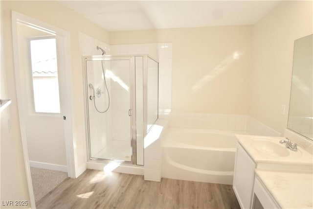 bathroom with vanity, a stall shower, wood finished floors, and a bath