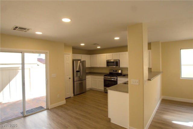 kitchen featuring visible vents, white cabinets, light wood-style flooring, stainless steel appliances, and recessed lighting