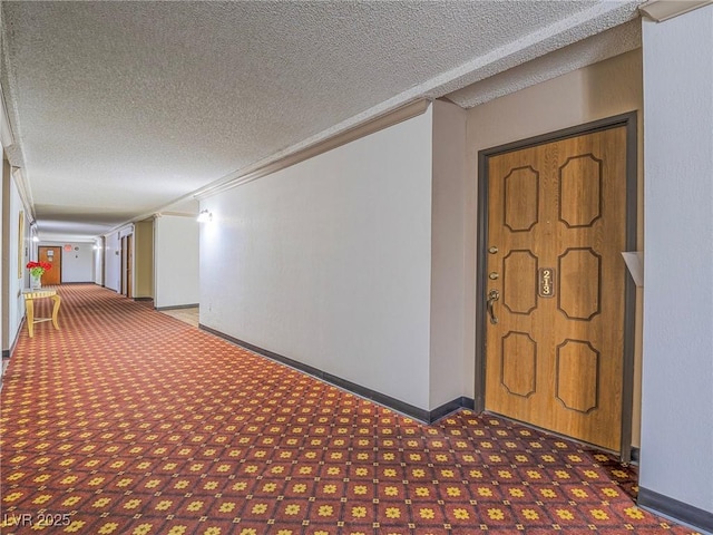 hallway featuring a textured ceiling and baseboards