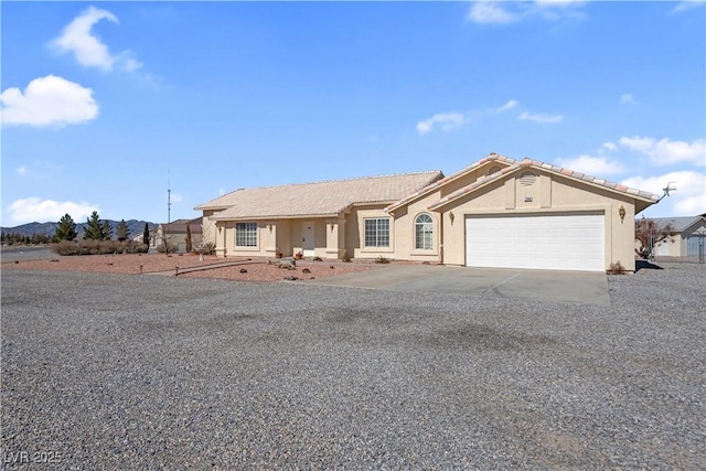 ranch-style home featuring driveway, an attached garage, and stucco siding