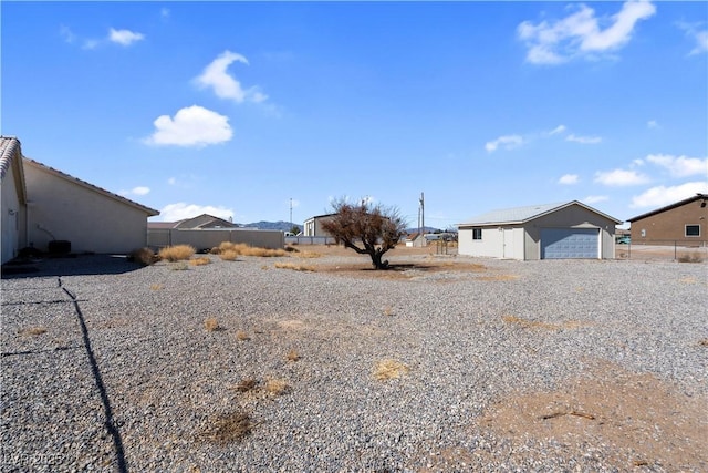 view of yard featuring an outbuilding, fence, and a detached garage