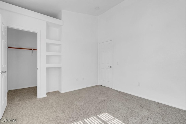 unfurnished bedroom featuring carpet, baseboards, and a closet