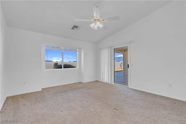 carpeted spare room featuring lofted ceiling, visible vents, and ceiling fan