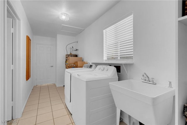 laundry area featuring light tile patterned floors, laundry area, a sink, independent washer and dryer, and attic access