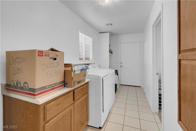 laundry area with visible vents, washer and dryer, and light tile patterned flooring