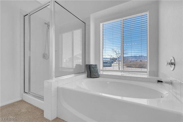 bathroom featuring a stall shower and a garden tub