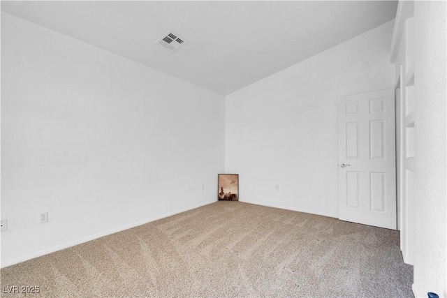 carpeted spare room with lofted ceiling and visible vents