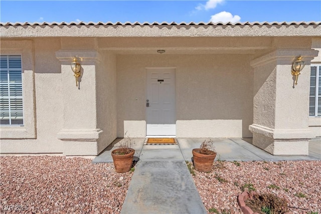 view of exterior entry with stucco siding