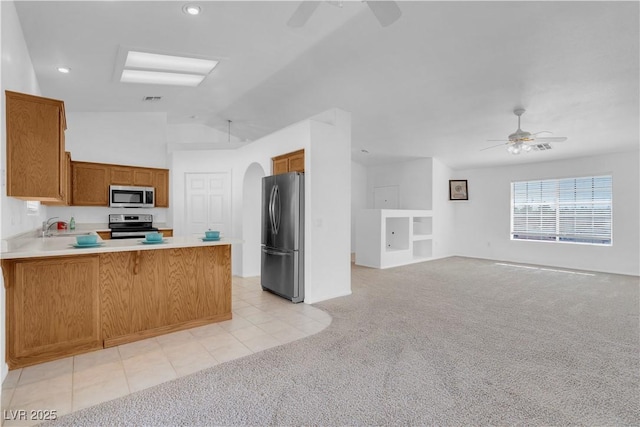 kitchen with stainless steel appliances, light colored carpet, and a ceiling fan