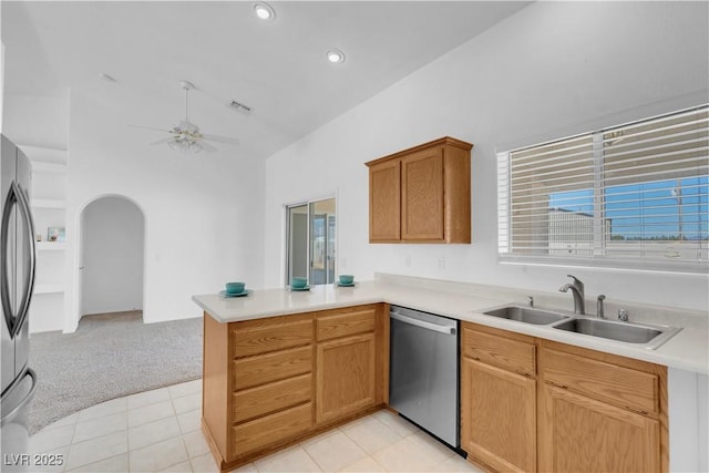 kitchen featuring arched walkways, a peninsula, a sink, visible vents, and appliances with stainless steel finishes