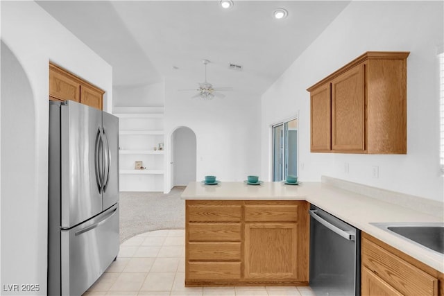 kitchen with arched walkways, ceiling fan, stainless steel appliances, a peninsula, and visible vents